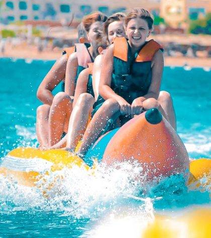 a group of 4 girls enjoying and having fun riding the banana boat ride